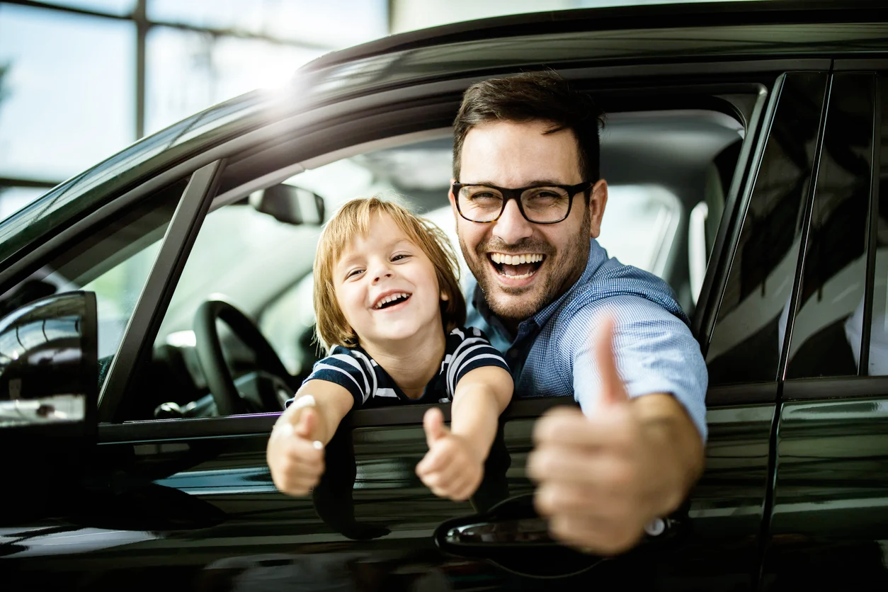 Family driving safely with car insurance document on the dashboard